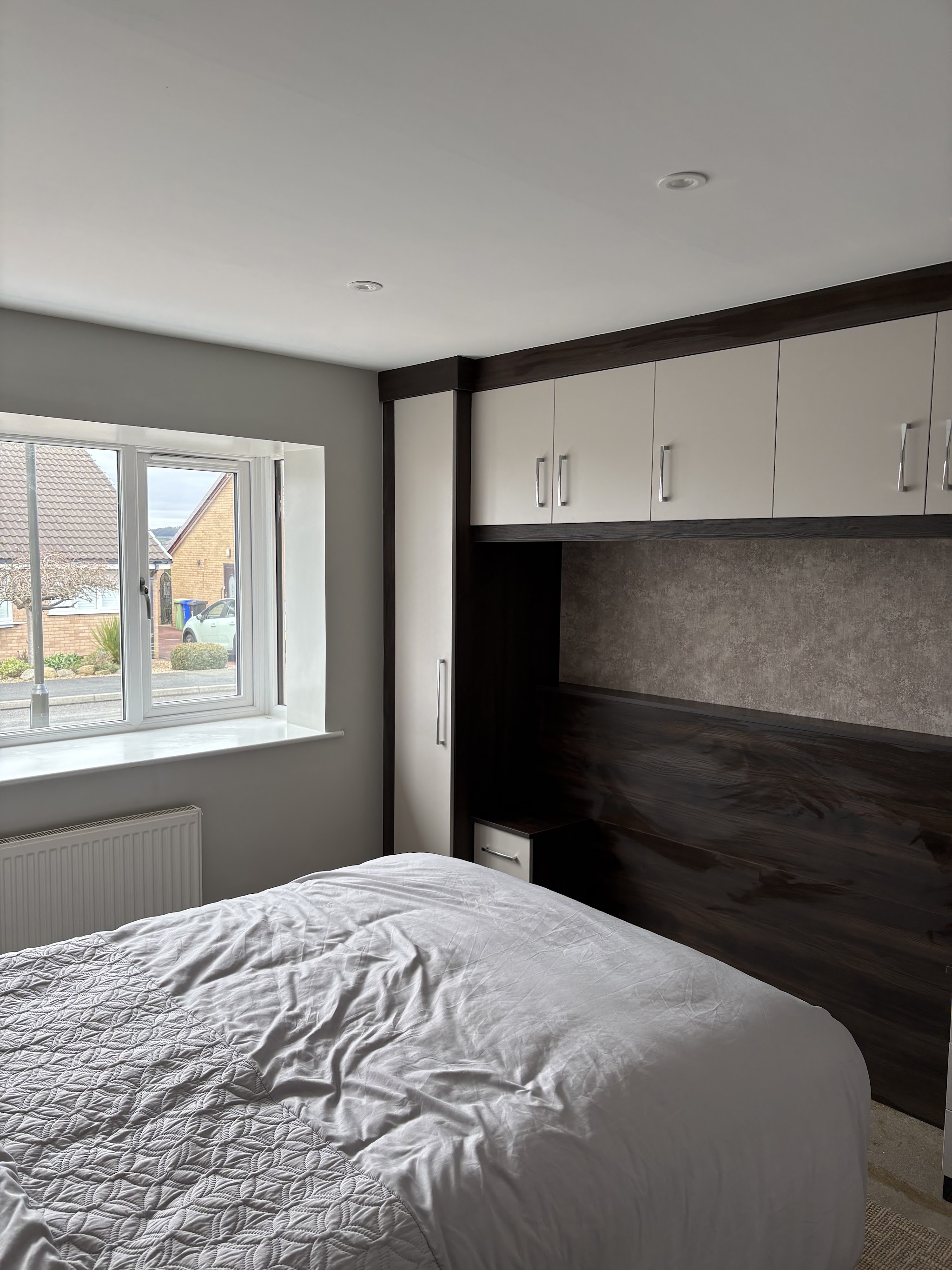The same bedroom after decorating, finished in grey with fitted wardrobes