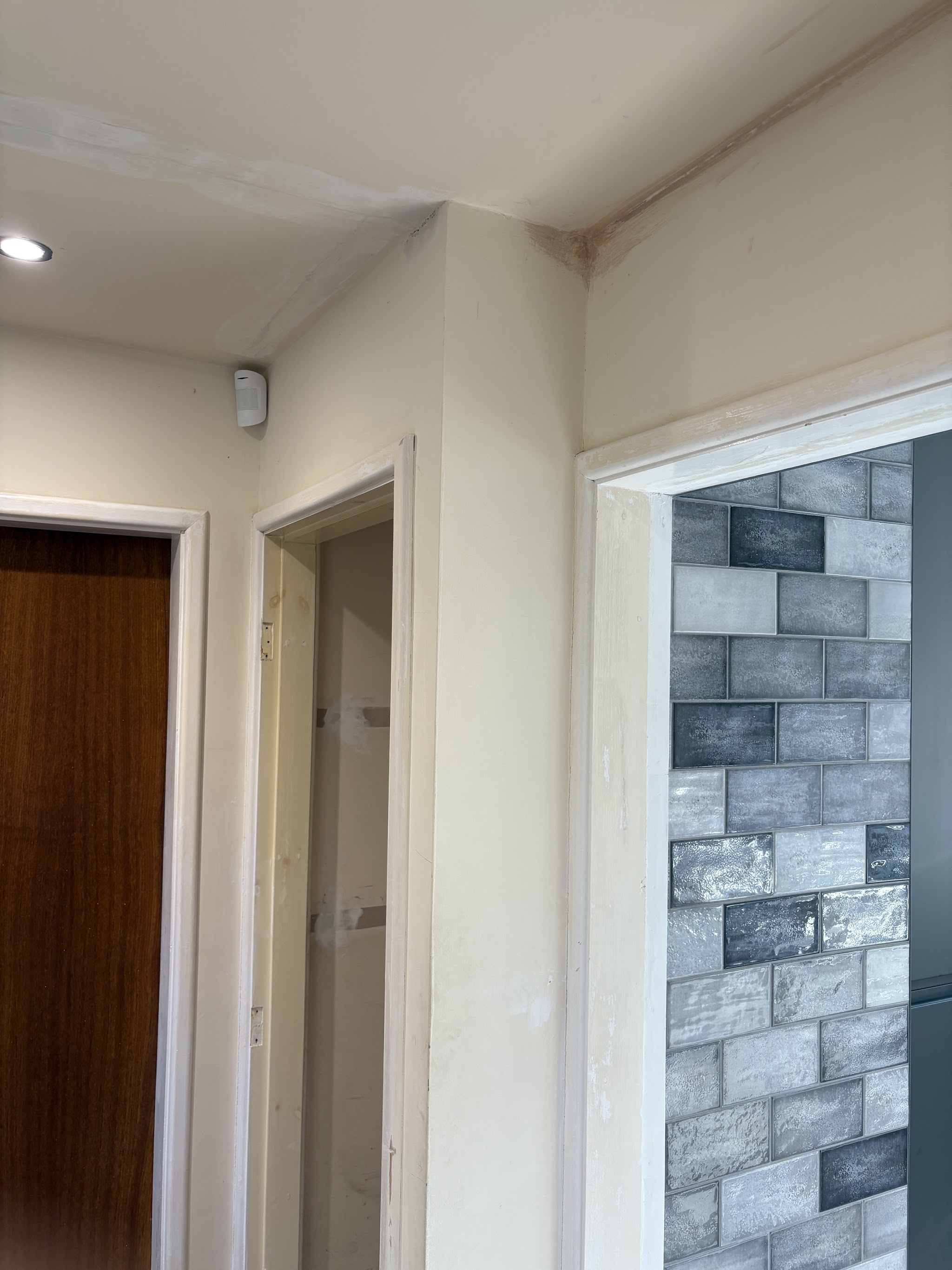 Finished hallway in soft cream with crisp white door frames